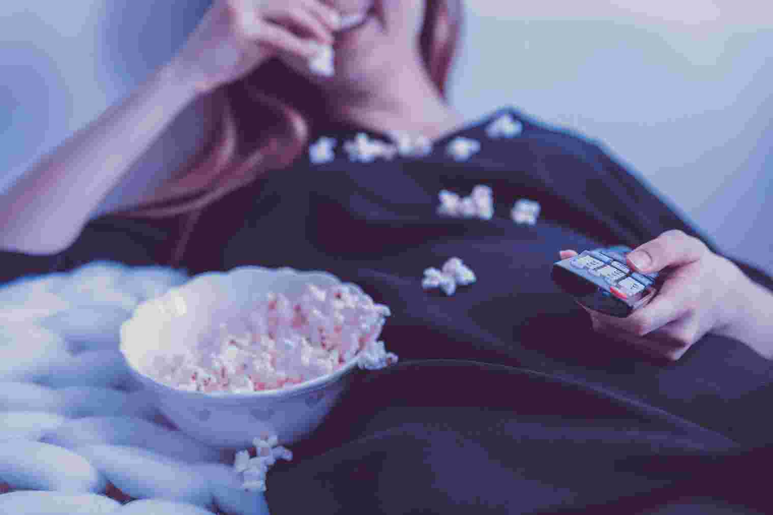 Dame isst Popcorn beim Fernsehen